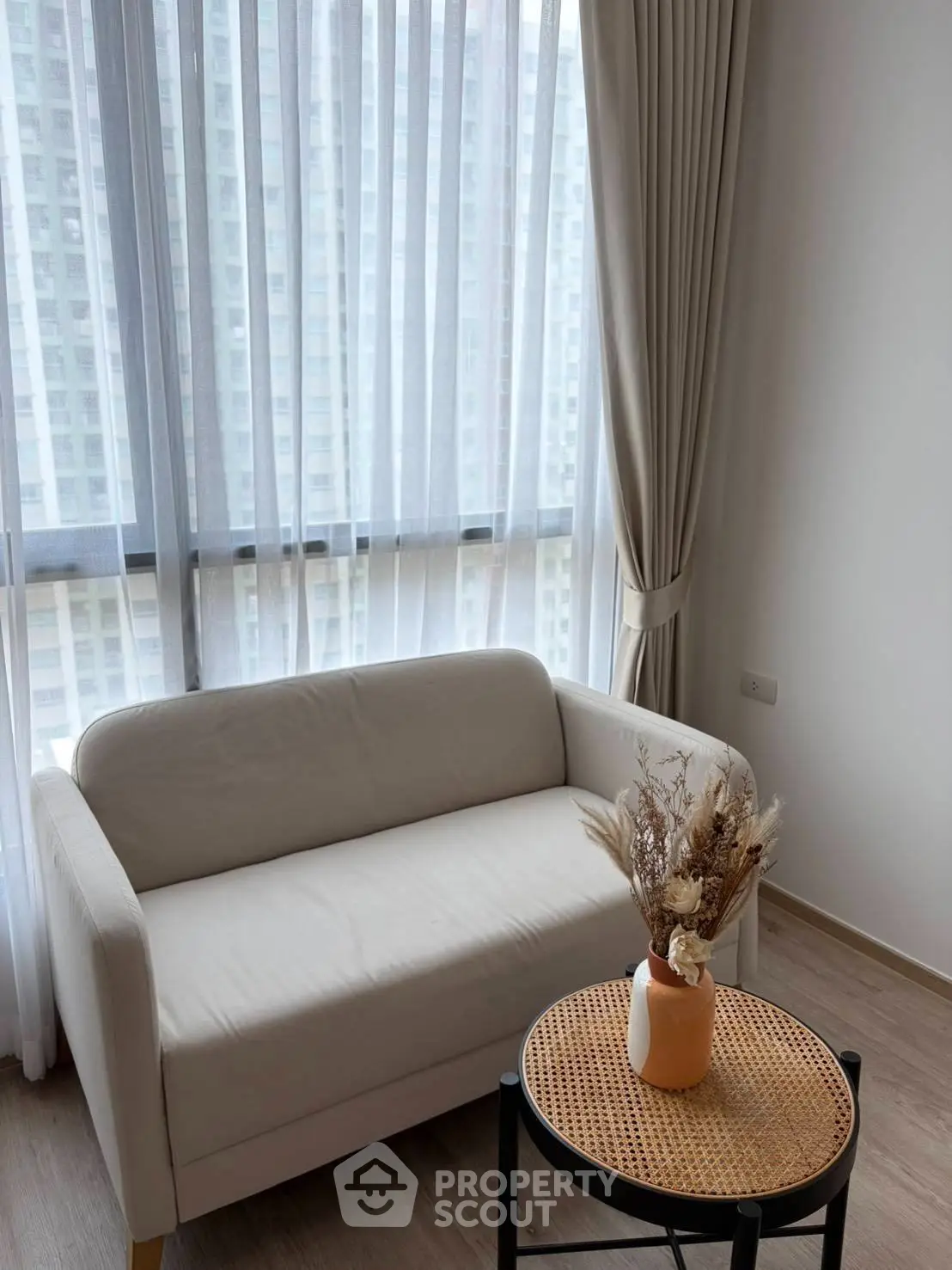 Cozy living room with modern sofa and city view through large windows