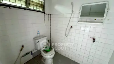 Basic bathroom with white tiles, toilet, and shower in a minimalist design.