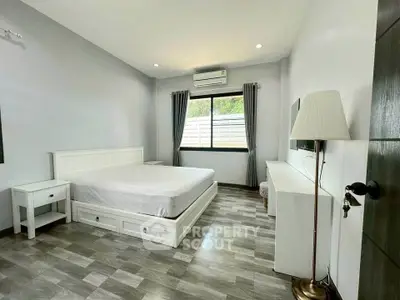 Spacious bedroom with modern furnishings and natural light