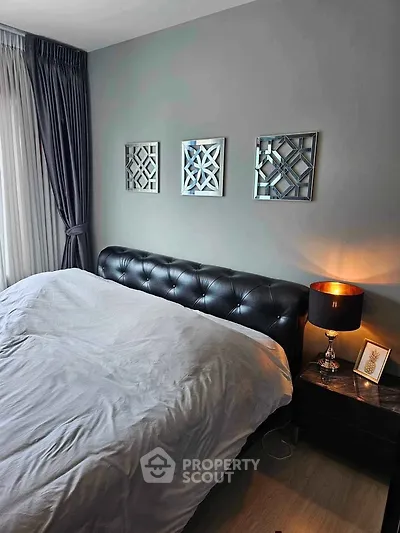 Elegant bedroom with stylish decor and natural light, featuring a plush bed and modern artwork.