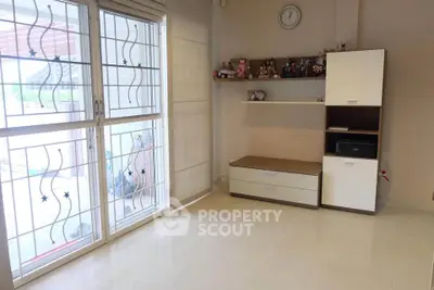 Spacious living room with modern shelving and large window for natural light.