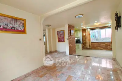 Spacious open-layout living area with tiled flooring and large windows