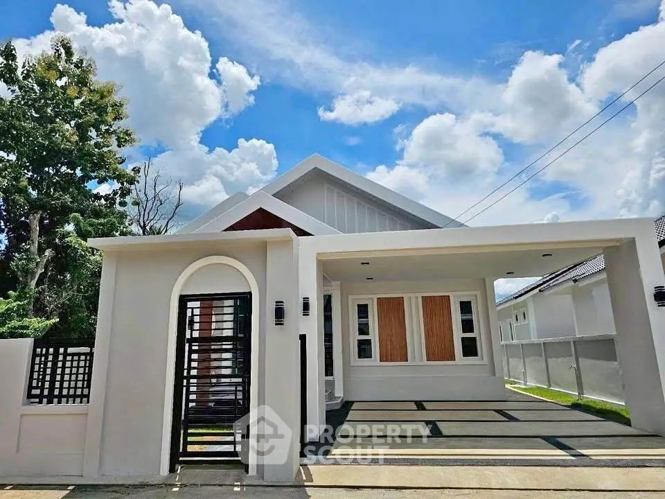 Modern single-story house with sleek design and spacious driveway under a bright blue sky.