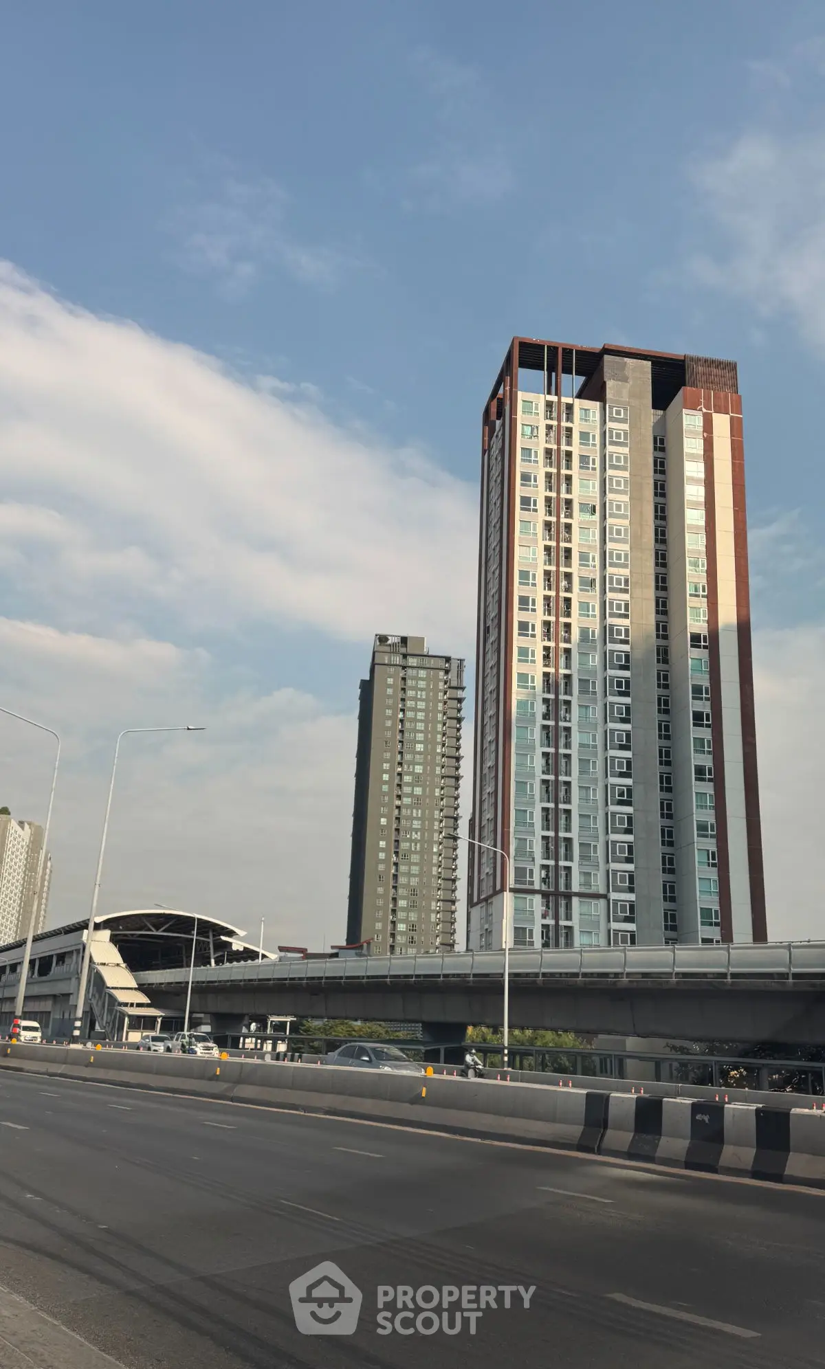 Modern high-rise buildings with adjacent highway and clear sky
