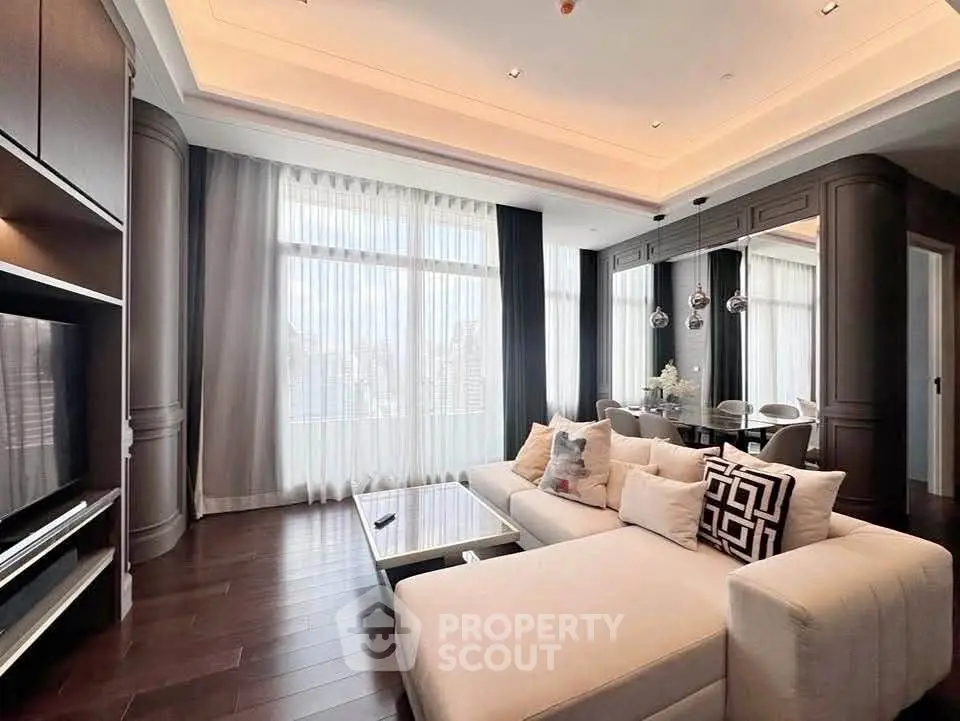 Luxurious modern living room with elegant decor and city view, featuring a spacious sectional sofa and stylish dining area.