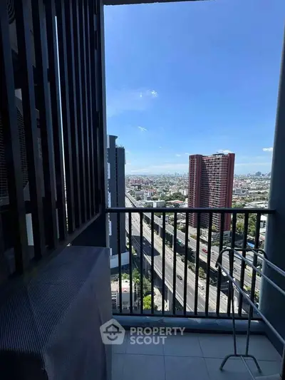 Stunning high-rise balcony view with cityscape and clear blue sky, perfect for urban living.