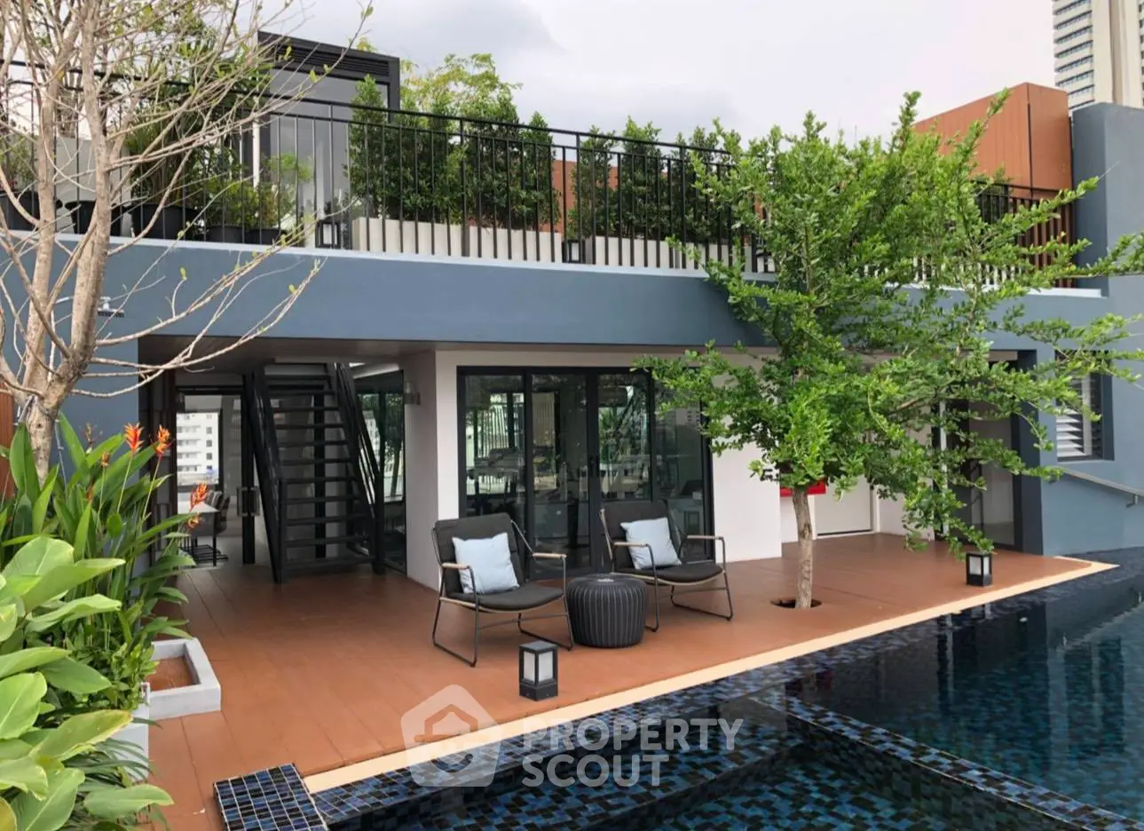 Luxurious rooftop pool area with modern design and lush greenery, perfect for relaxation and entertainment.