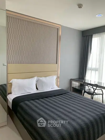 Modern bedroom with stylish decor and natural light, featuring a cozy bed and sleek workspace.
