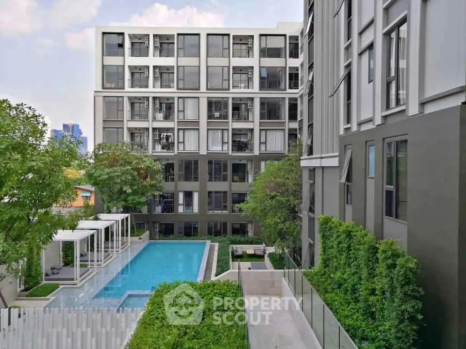 Modern apartment building with pool and lush greenery, perfect for urban living.