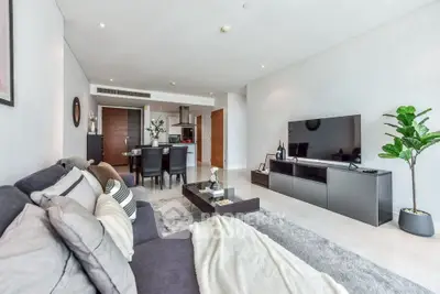 Modern living room with sleek furniture and open layout, featuring a cozy sofa and large TV unit.