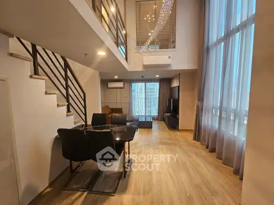 Spacious modern living room with high ceilings and elegant staircase in luxury apartment