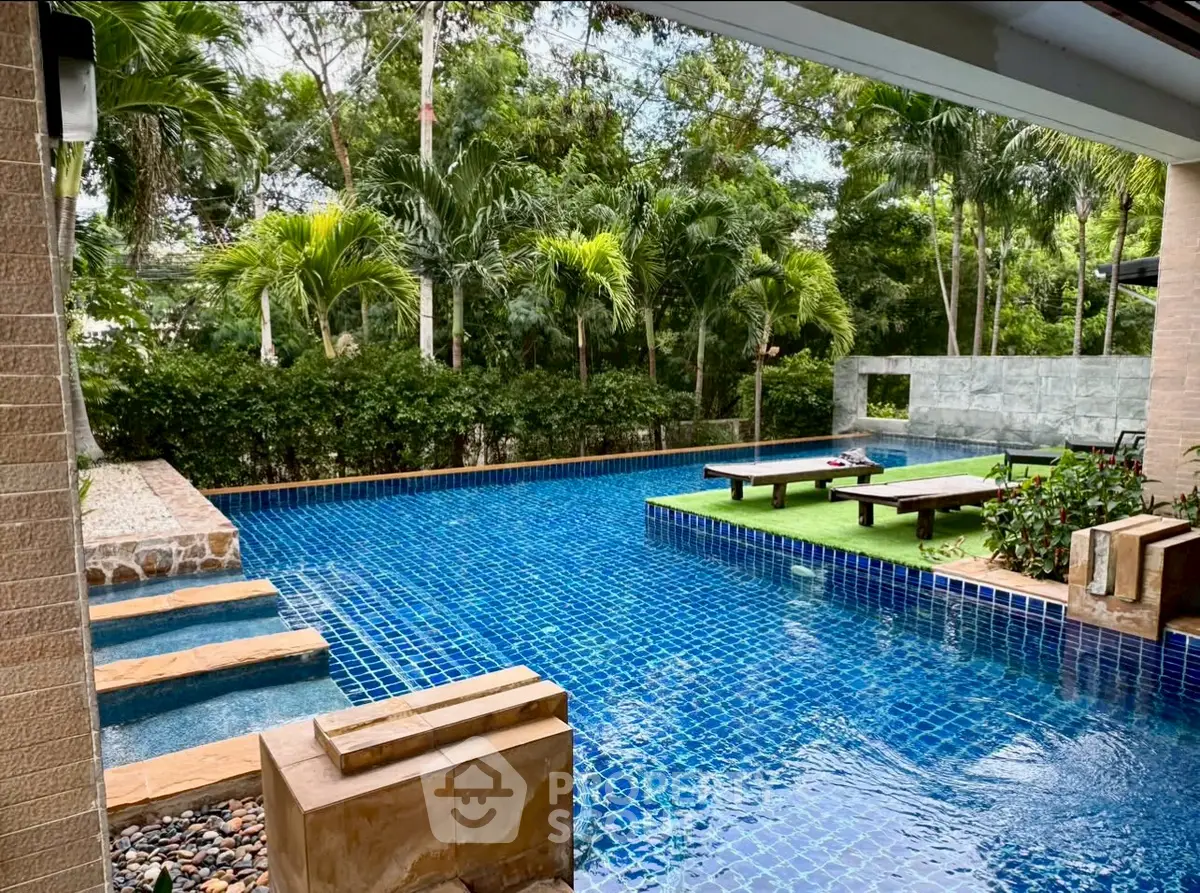 Luxurious outdoor pool area with lush greenery and modern design.