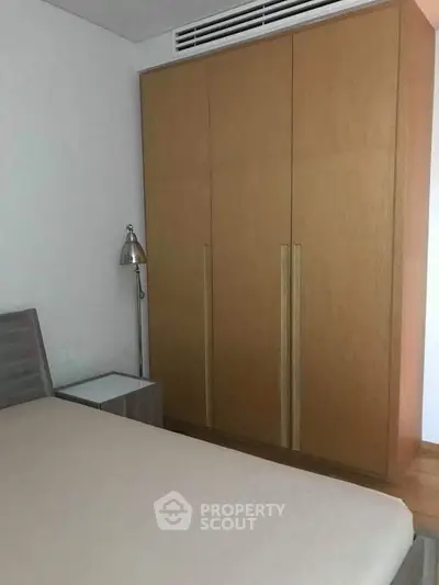 Cozy bedroom with wooden wardrobe and modern lamp