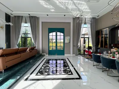 Luxurious living room with high ceilings, elegant decor, and large windows offering abundant natural light.