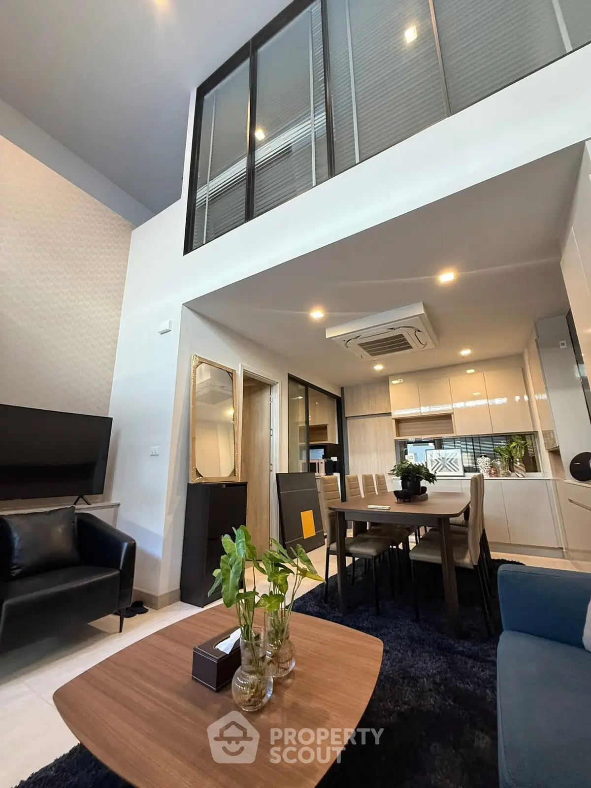 Modern duplex living room with stylish decor and open kitchen layout