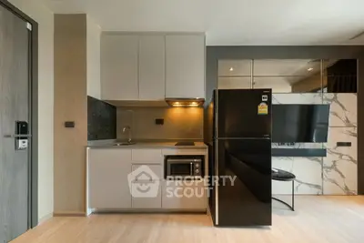 Modern kitchen with sleek appliances and stylish cabinetry in a contemporary apartment.