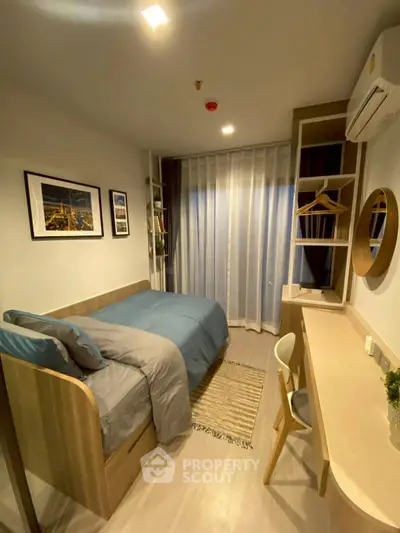 Cozy bedroom with modern decor, featuring a comfortable bed, stylish desk, and ample natural light from large window.