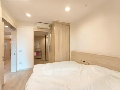 Modern bedroom with wooden accents and built-in wardrobe in a cozy apartment.