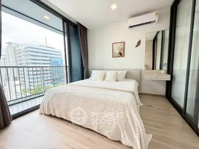 Modern bedroom with large windows and city view, featuring a cozy bed and air conditioning.