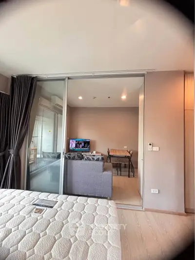 Modern apartment interior with cozy living room and bedroom, featuring sliding glass doors and stylish decor.