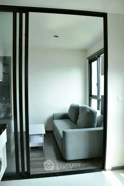 Cozy small living room with modern gray sofa and natural light