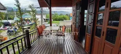 Charming wooden balcony with outdoor seating and scenic view, perfect for relaxation and entertaining.