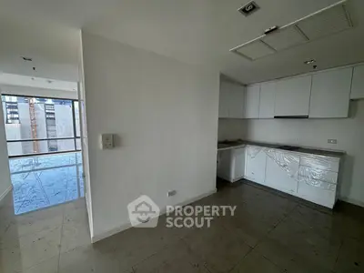 Modern kitchen with sleek white cabinets and open layout in a high-rise apartment.