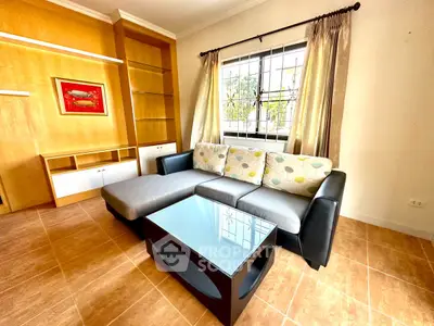 Spacious living room with modern sofa and large window, perfect for relaxation.