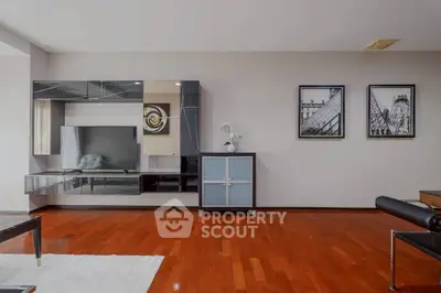 Spacious modern living room with sleek wooden flooring and stylish wall decor.