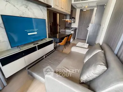 Modern living room with sleek furniture and open kitchen layout in a stylish apartment.