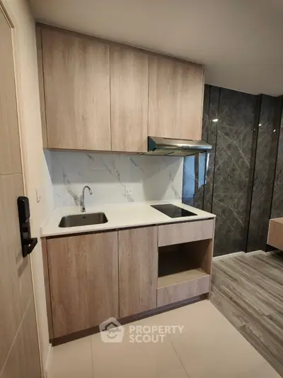 Modern kitchen with sleek wooden cabinets and marble backsplash