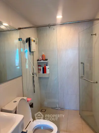 Modern bathroom with glass shower enclosure and sleek fixtures