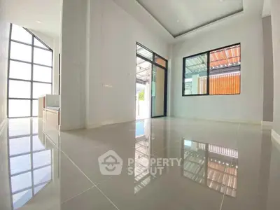 Spacious modern living room with large windows and glossy tiled floors