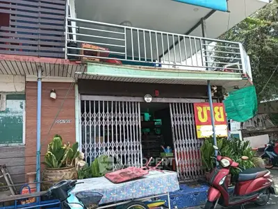 Charming two-story building with balcony and street-level shop entrance.