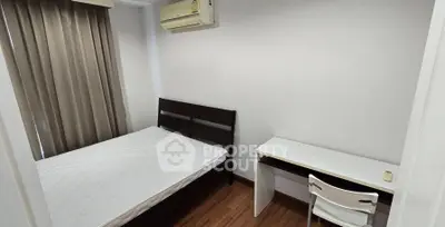 Cozy bedroom with wooden flooring, modern bed, and study desk in a minimalist style.