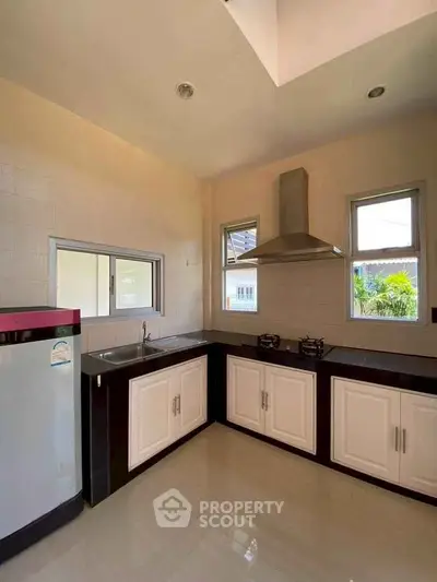 Modern kitchen with sleek cabinetry and gas stove in a bright, airy space.