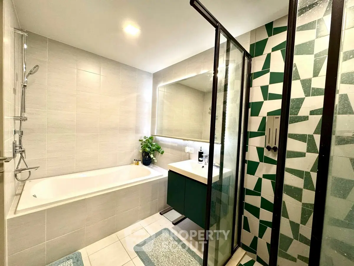 Modern bathroom with bathtub and geometric tile shower in stylish apartment.