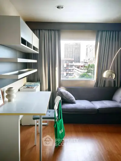 Modern living room with city view, stylish sofa, and sleek shelving in a cozy apartment.