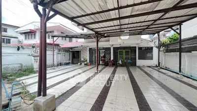 Spacious covered patio area with tiled flooring and open layout, perfect for outdoor gatherings.