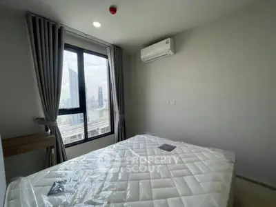 Modern bedroom with city view, featuring large window and air conditioning.
