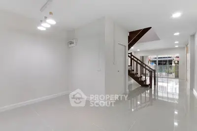Spacious modern interior with sleek staircase and glossy tiled floors, perfect for contemporary living.