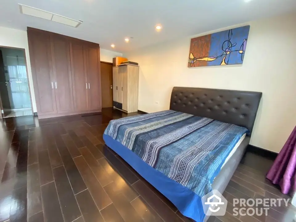 Spacious bedroom with modern decor and large wardrobe in luxury apartment