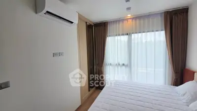 Cozy bedroom with air conditioning and large window for natural light