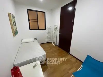 Cozy minimalist bedroom with single bed and wooden flooring, ideal for compact living spaces.