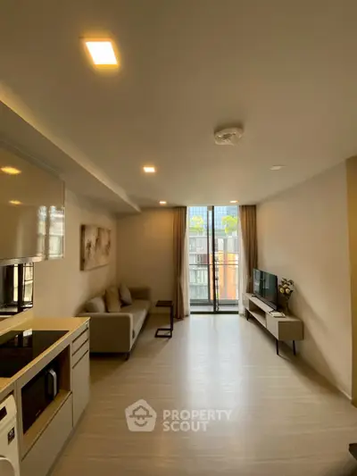Modern living room with open layout and balcony view in a stylish apartment.