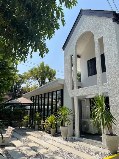 Charming modern house exterior with lush greenery and sleek architectural design.