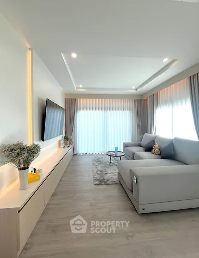 Modern living room with sleek design, large sofa, and natural light.