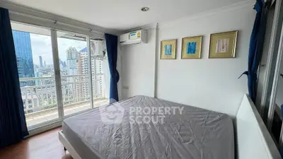 Spacious bedroom with city view and balcony access in modern apartment