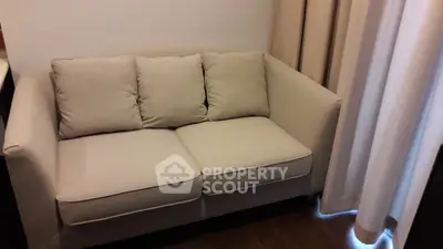 Cozy beige sofa in a modern living room with elegant curtains.