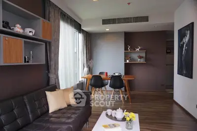Modern living room with stylish decor and dining area, featuring elegant furniture and natural light.
